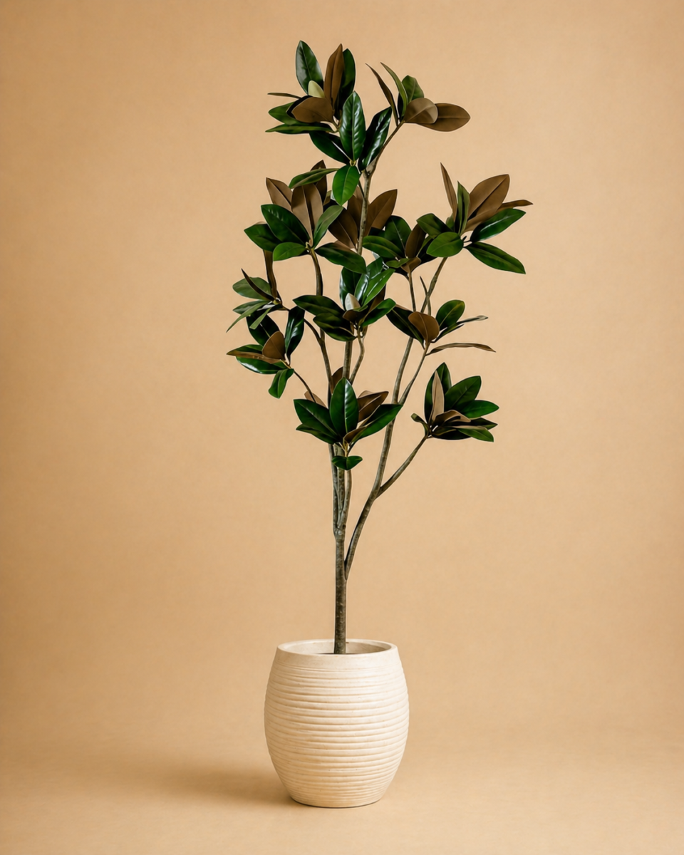 Premium faux magnolia tree in a white planter on warm neutral background