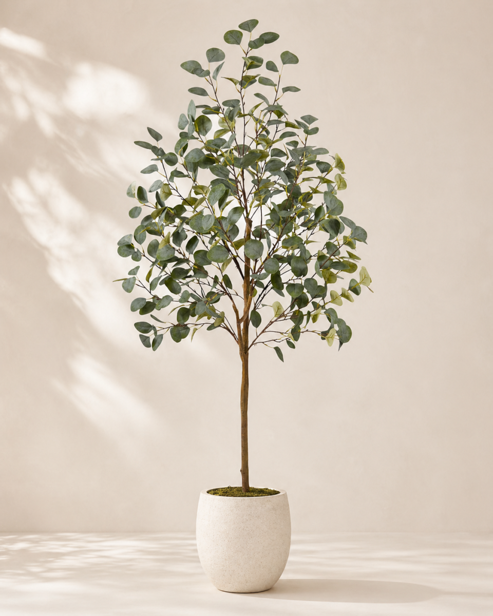 Premium faux eucalyptus tree in a white planter on warm neutral background
