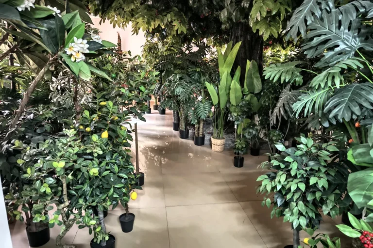Verdant Nest artificial tree showroom with assorted faux greenery samples